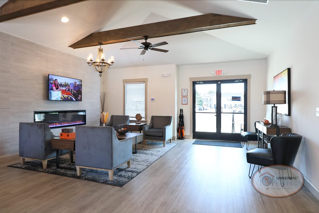 The interior of the clubhouse and leasing office with flat screen TV, lounge seating, and ceiling fan.
