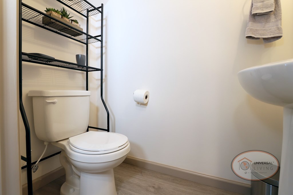 A half-bathroom with white walls, toilet, and sink.