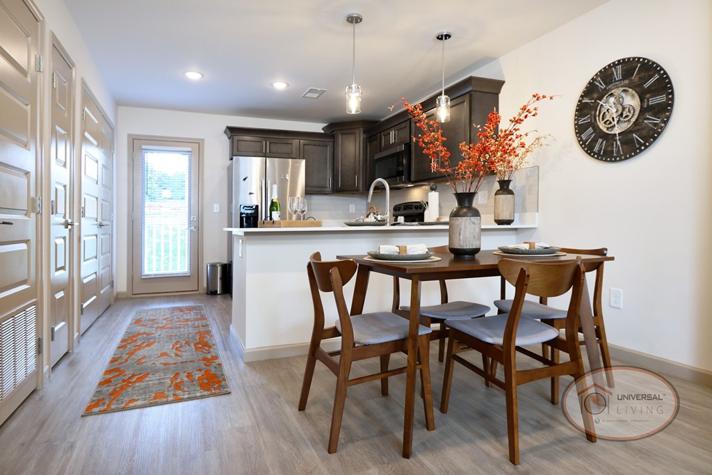 A kitchen with a dining table and chairs with the patio door visible in the background.