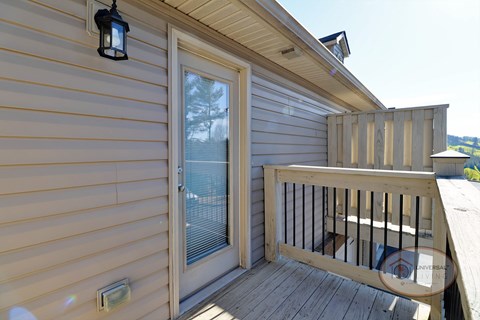 A balcony with glass door overlooking the property.