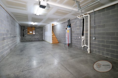 A large interior image of a garage with stairs leading to the apartment home above.