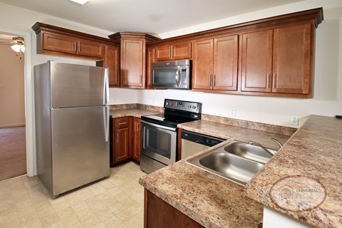 A kitchen with a granite counter top and stainless steel appliances.