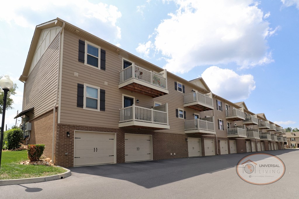 The rear of a one bedroom stacked apartment home with balconies and garages.