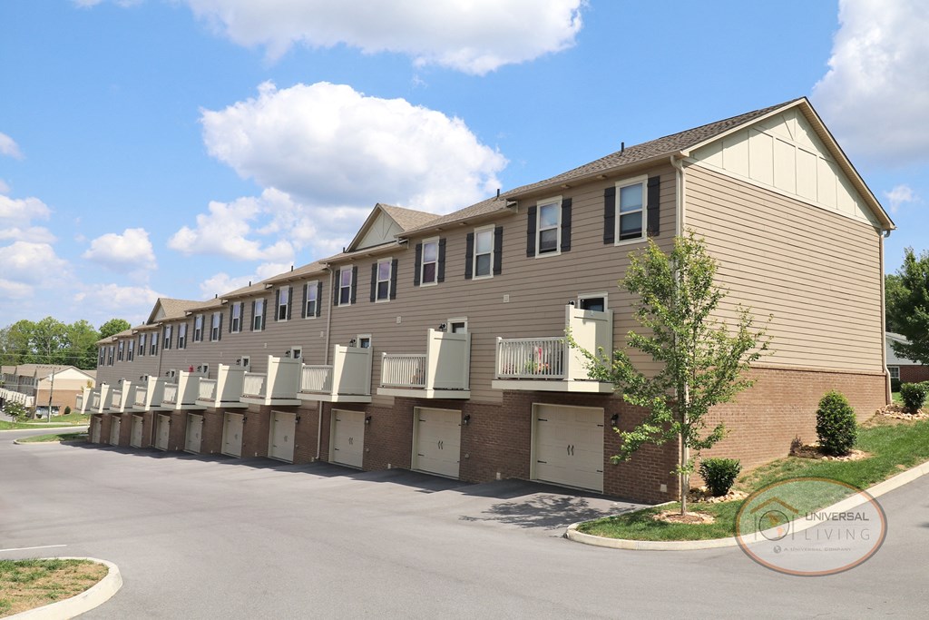 The rear of a two/three bedroom apartment home with balconies and drive under garages.