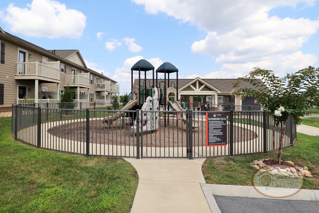 A fenced in playground with a slide and jungle gym.
