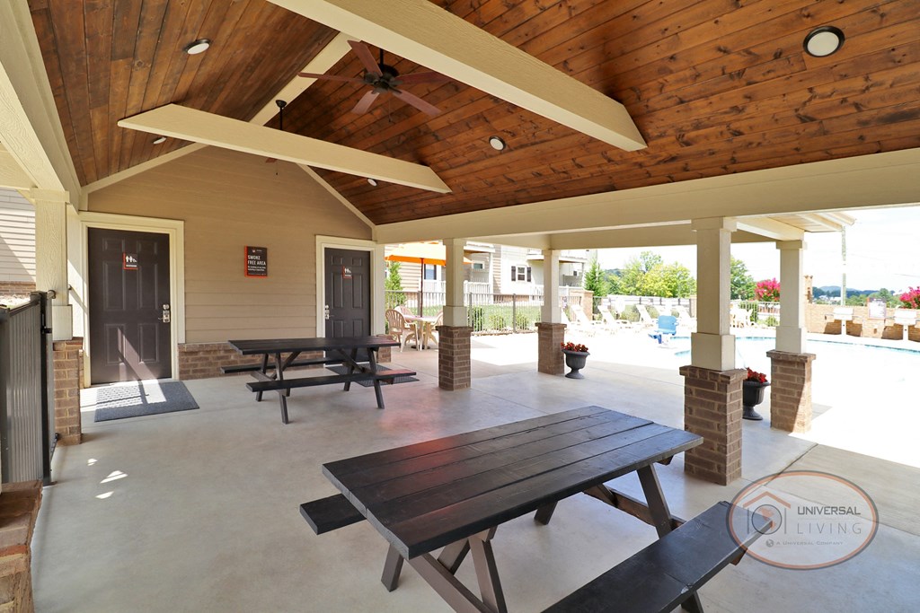 The poolside patio with picnic tables and ceiling fans.