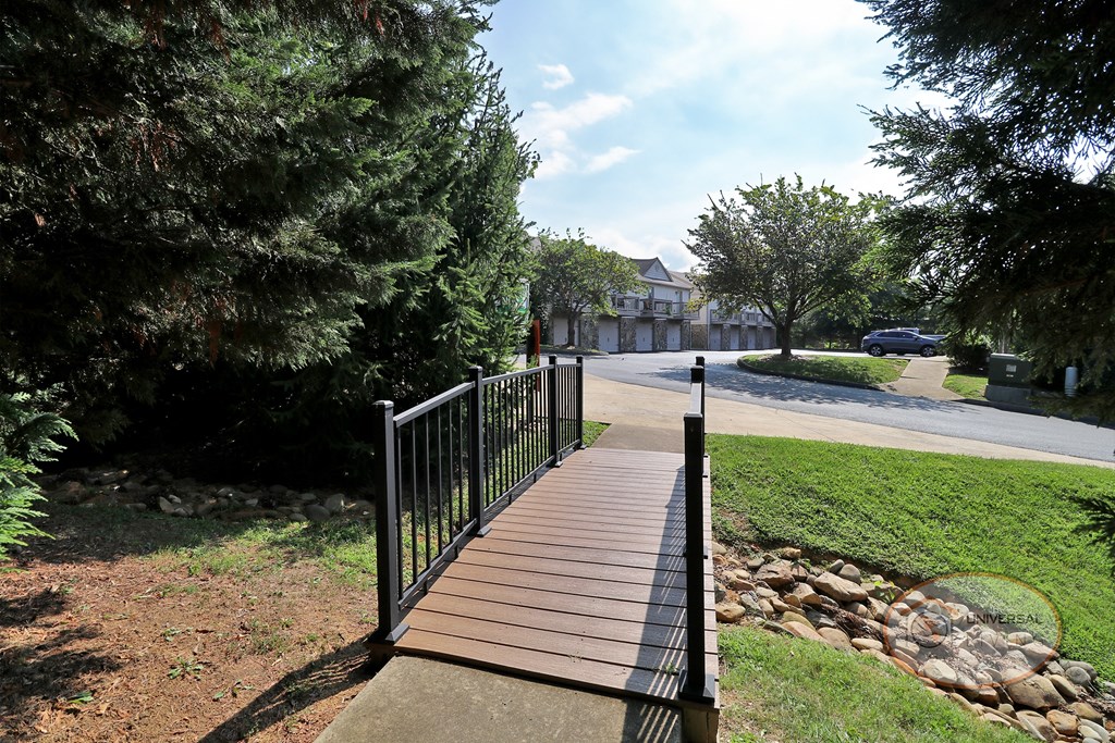 a bridge in a park with a road and trees