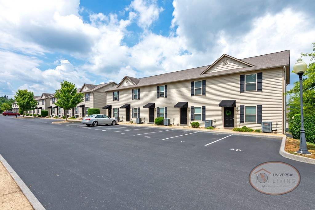 an empty parking lot in front of an apartment building