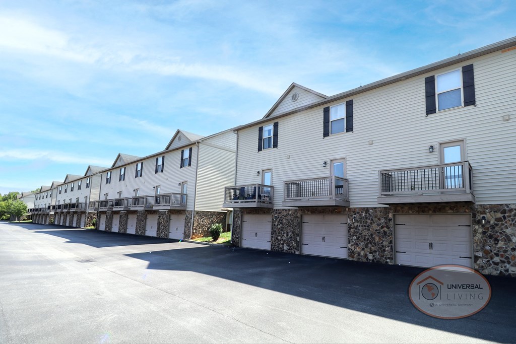 a row of white houses with balconies and a parking lot