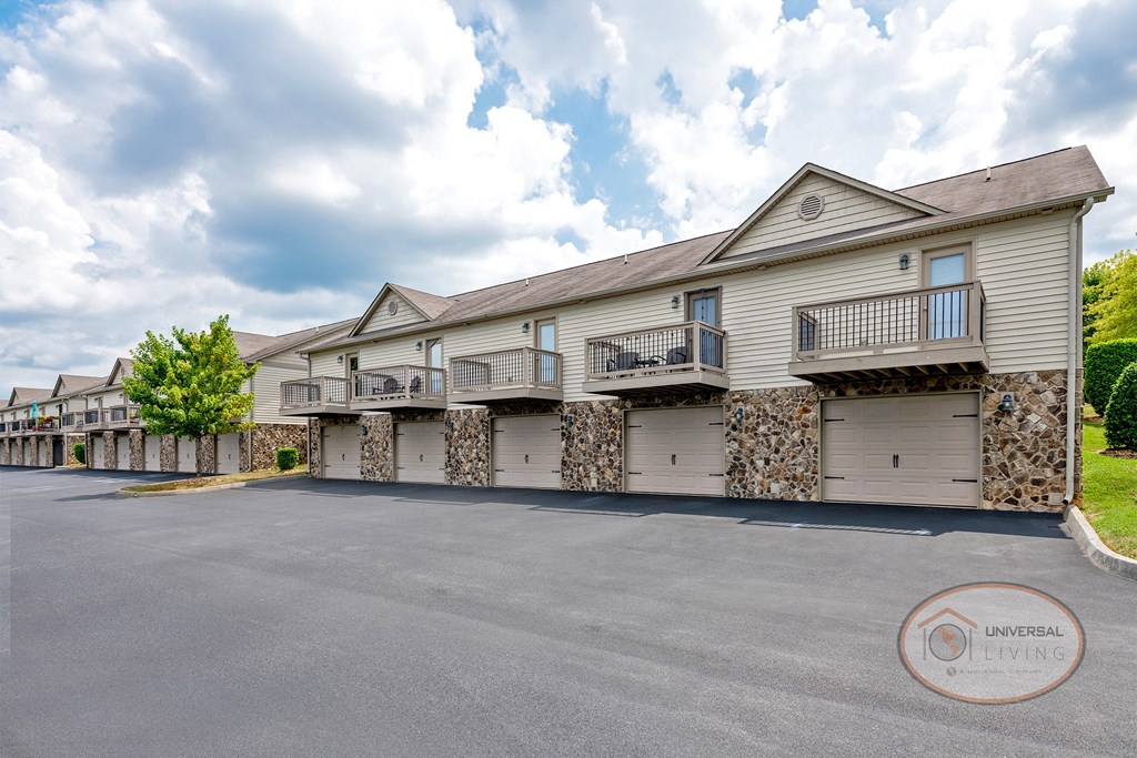 an empty parking lot in front of a building with two garages