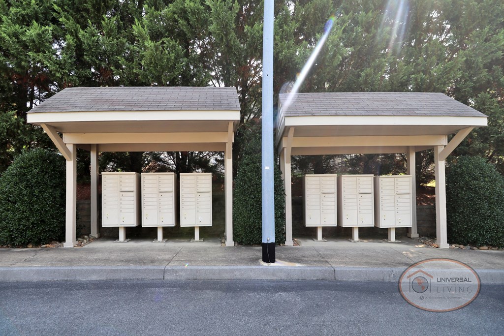a kiosk with mailboxes on the side of a street