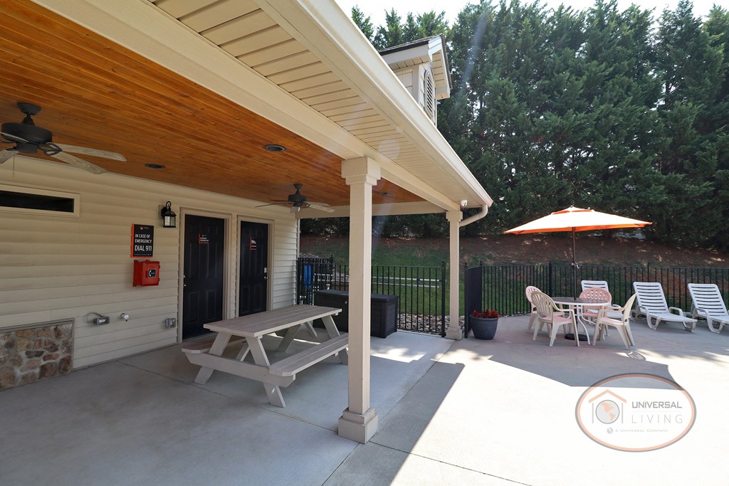 a covered patio with a picnic table and chairs