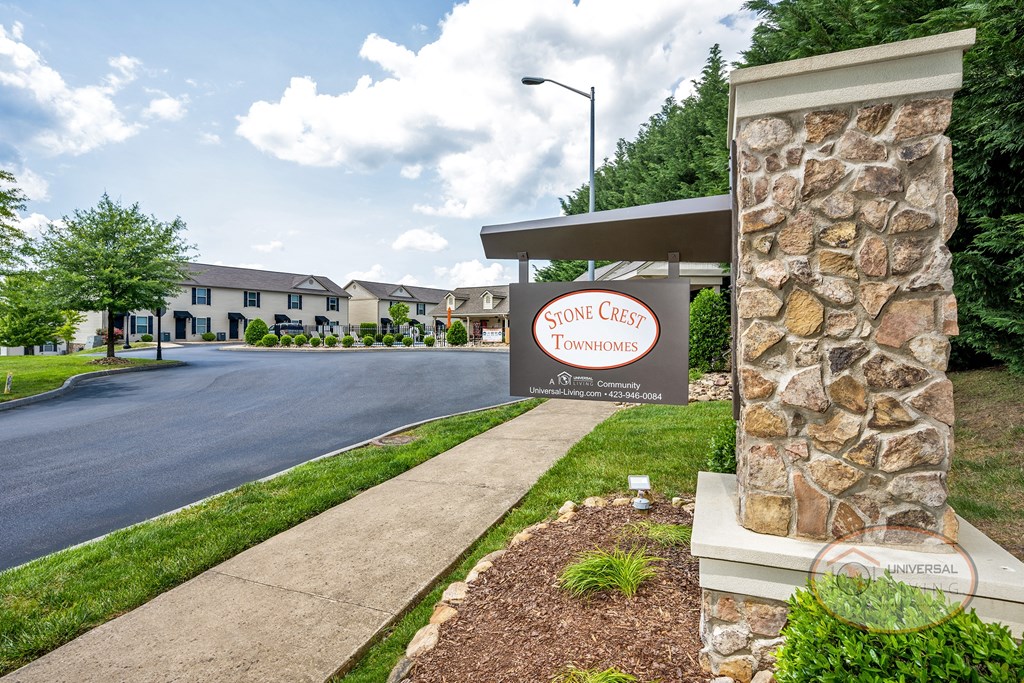 a stone building with a sign on the side of a road