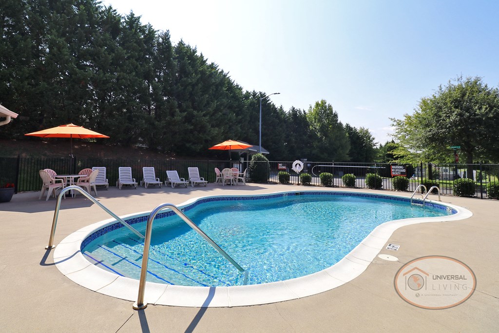 a pool with chairs and umbrellas at a resort pool