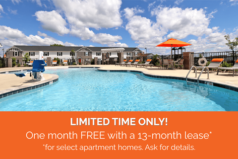 A pool surrounded by chairs and umbrellas with a sign offering a free month with a 13-month lease for select apartment homes.