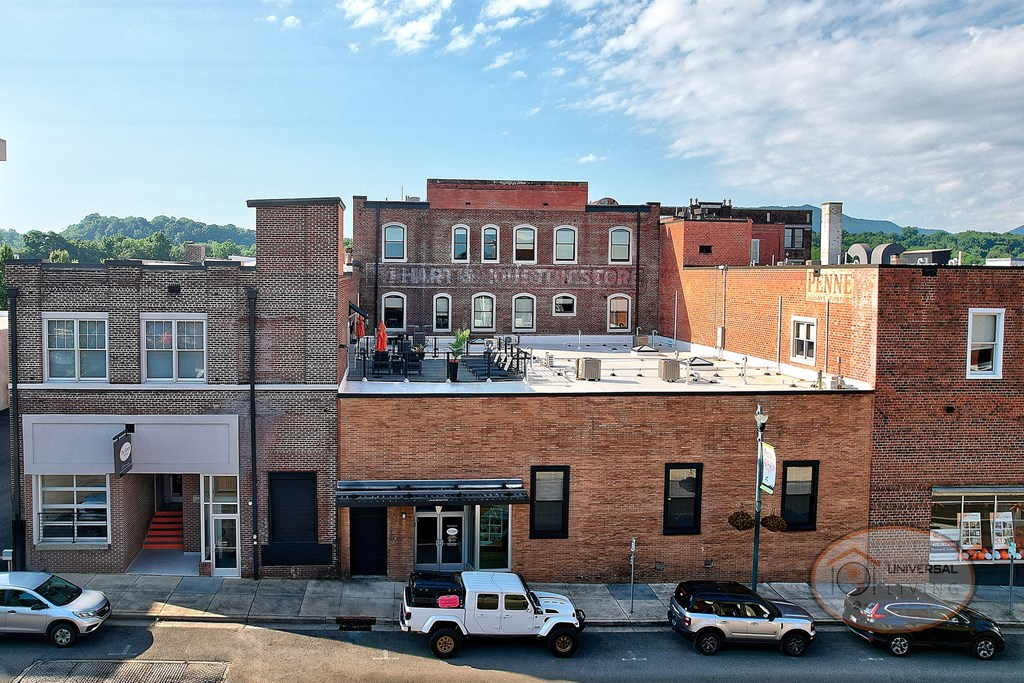 The Henry on Main, Apartment Homes in Johnson City, Tennessee. A view of the Front of The Henry on Main, a historic brick building in downtown Johnson City, TN, with a visible rooftop patio.