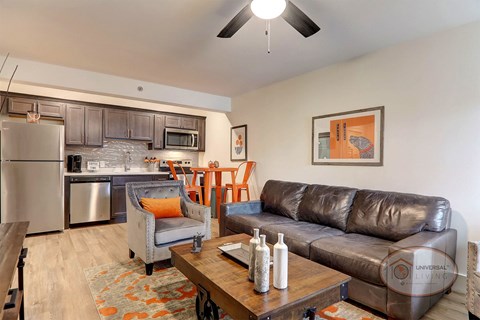 A living room with a brown leather couch and a grey armchair.