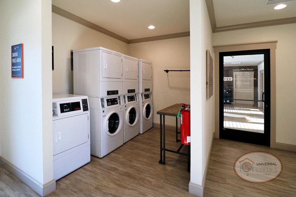 A community laundry center with washers, dryers, and table.