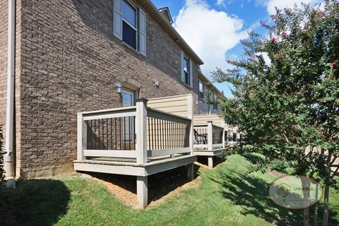 The rear of a row of apartment buildings with patios.