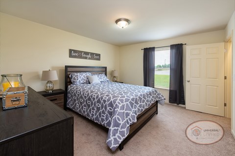 A bedroom with a bed, nightstand, closet and window.
