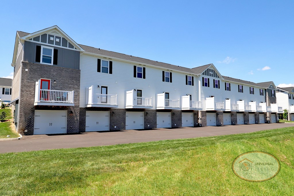 The rear of a two and three bedroom apartment home with balconies and drive under garages.