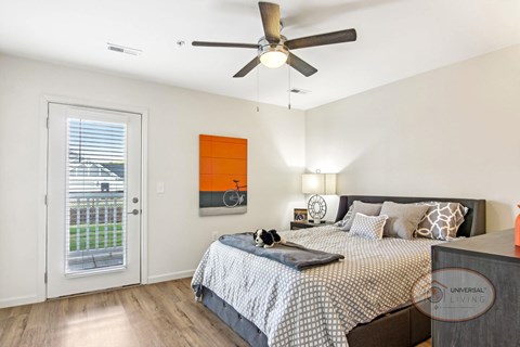 A bedroom with a bed, a ceiling fan, and a window with blinds.