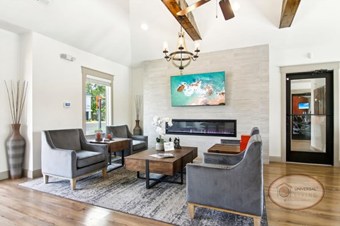A living room with a grey couch, a coffee table, and a painting on the wall.