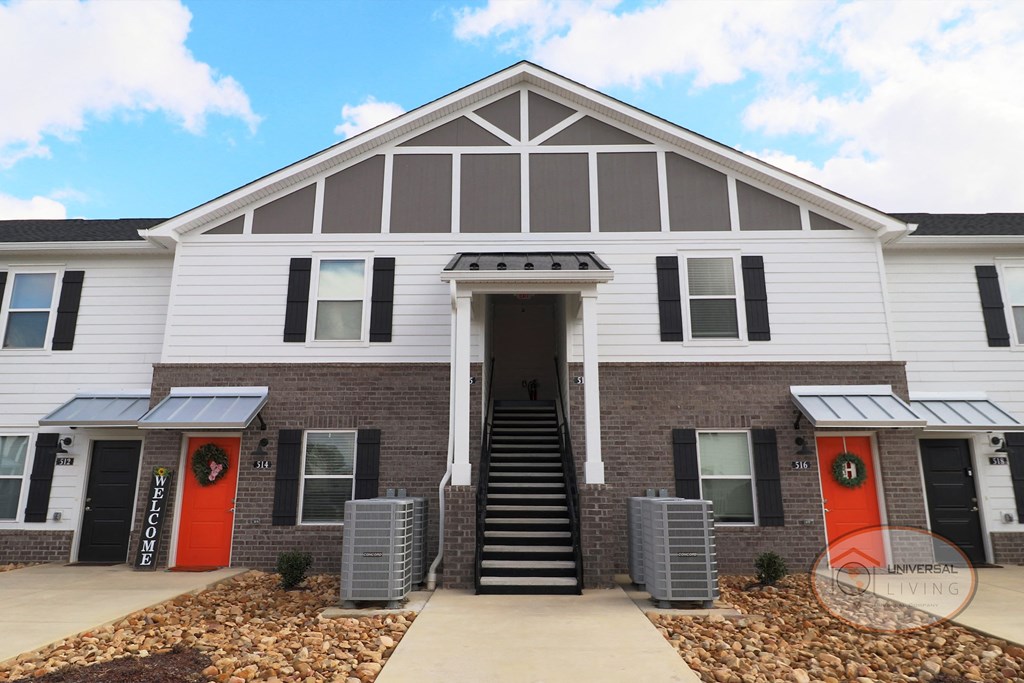 a white house with red doors and a porch