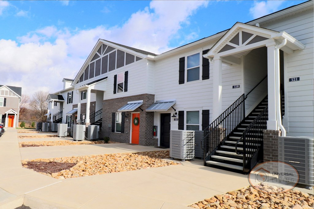 a group of white houses with stairs and a sidewalk