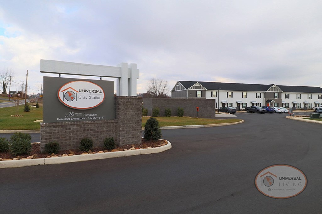 a sign in front of a building with a parking lot