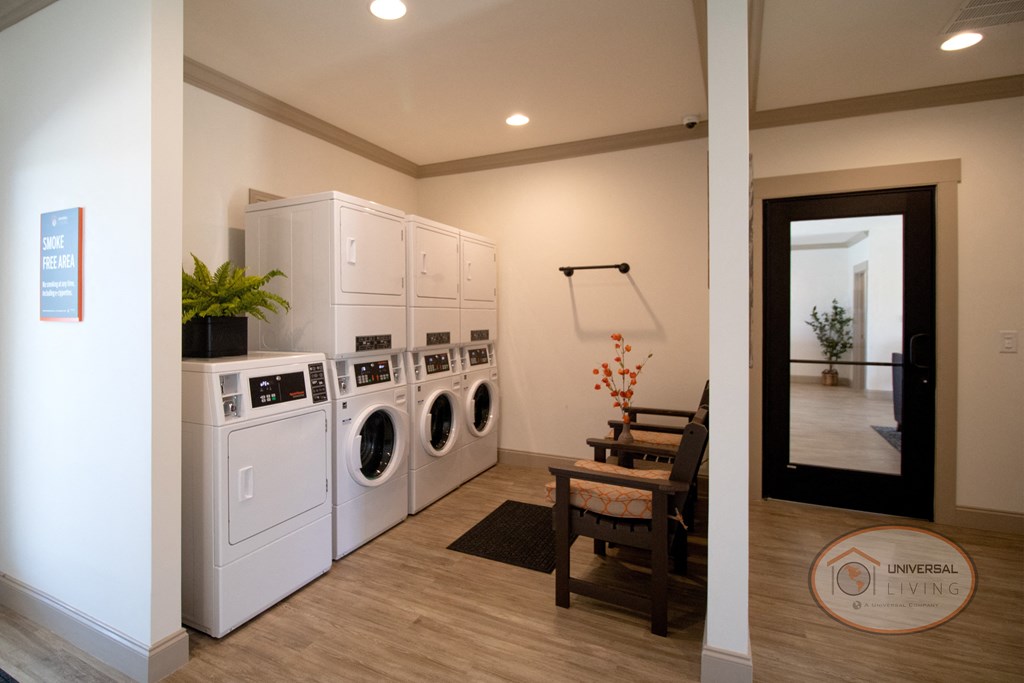 a laundry room with washer and dryer and a dining room table with chairs