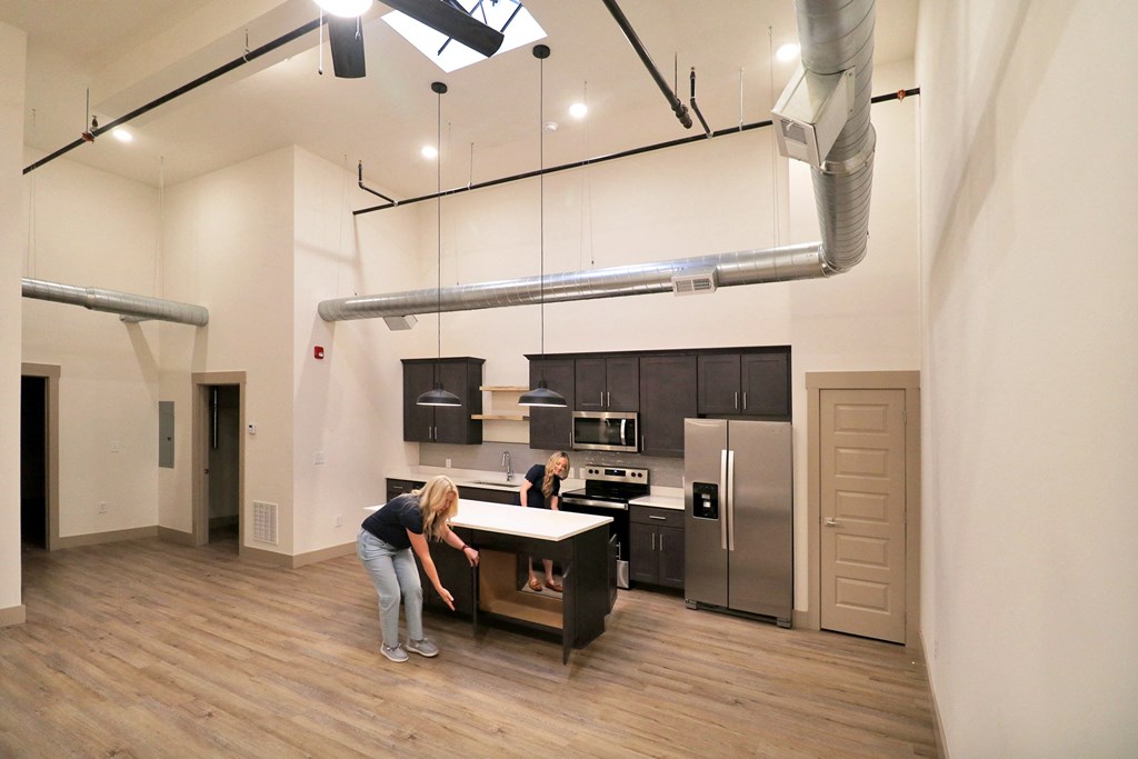 Two women exploring the empty kitchen of an apartment home.