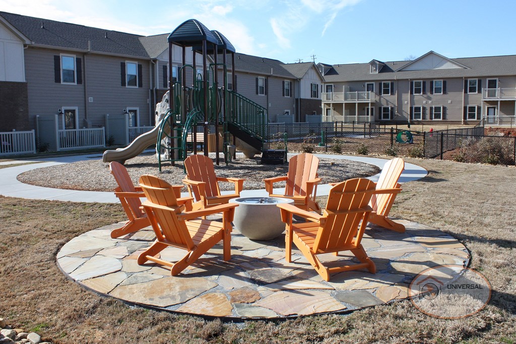 A firepit on a stone patio with seating.