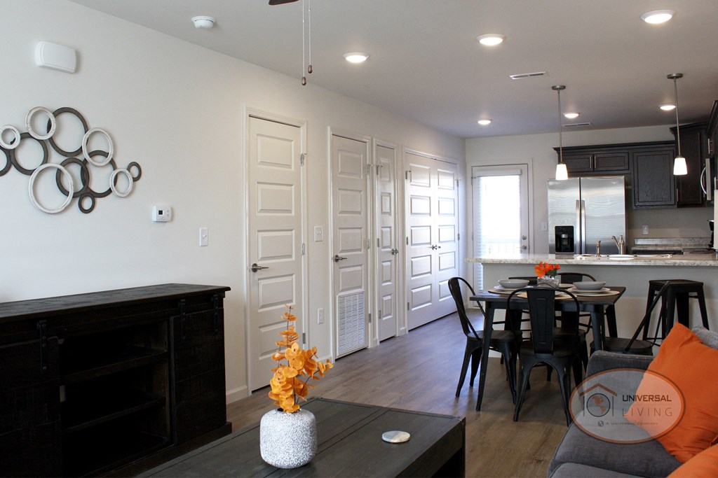 A view of the closets, bathroom door, and panty in the living and kitchen area.