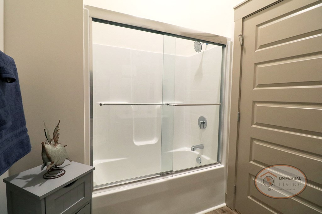 A shower with a glass door in a bathroom.