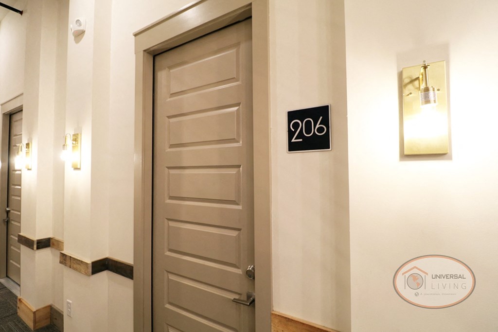A door in a hallway with a sign that says 206 on it.