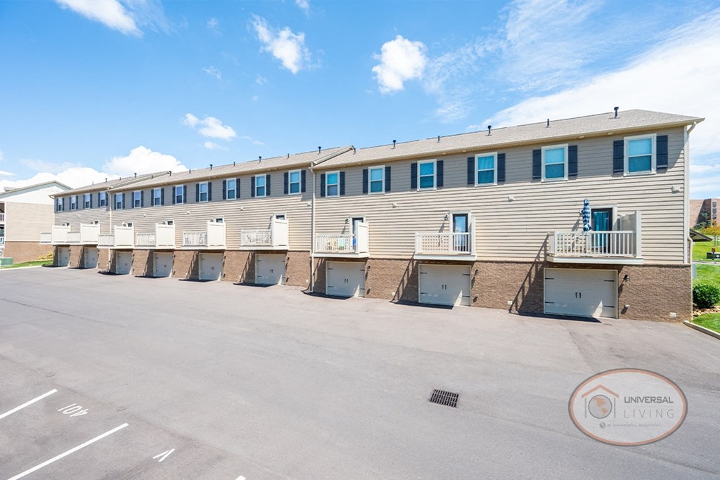 Back of tan apartment building with garages.