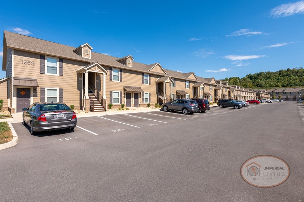 Front of two story, tan, apartment building.