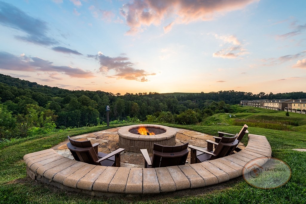 A fire pit overlooking the mountains with chairs.