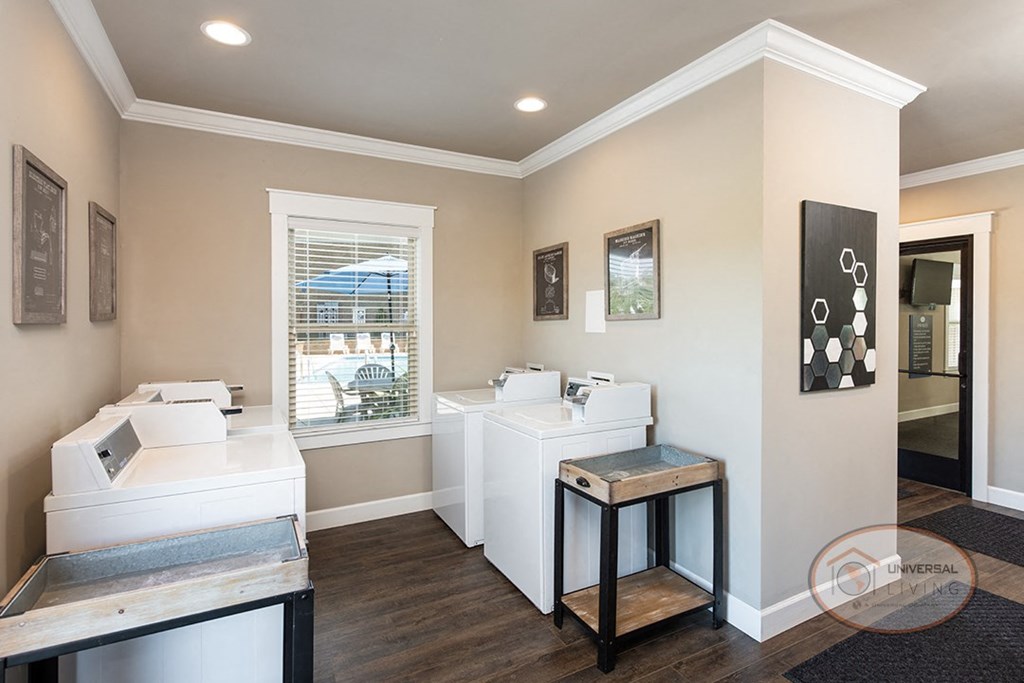 Laundry center with washing machines, dryers, and tables.