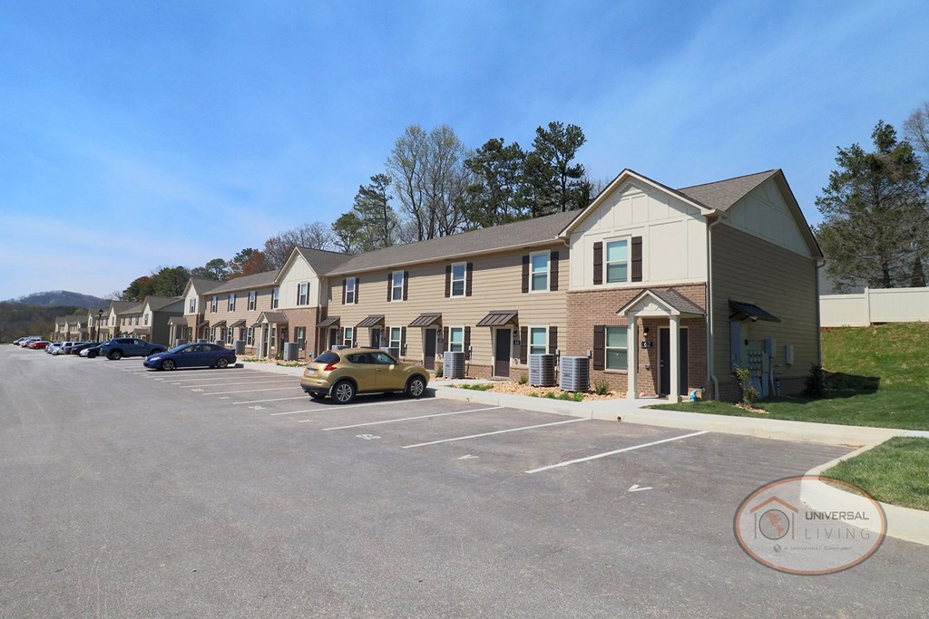 an empty parking lot in front of a row of houses