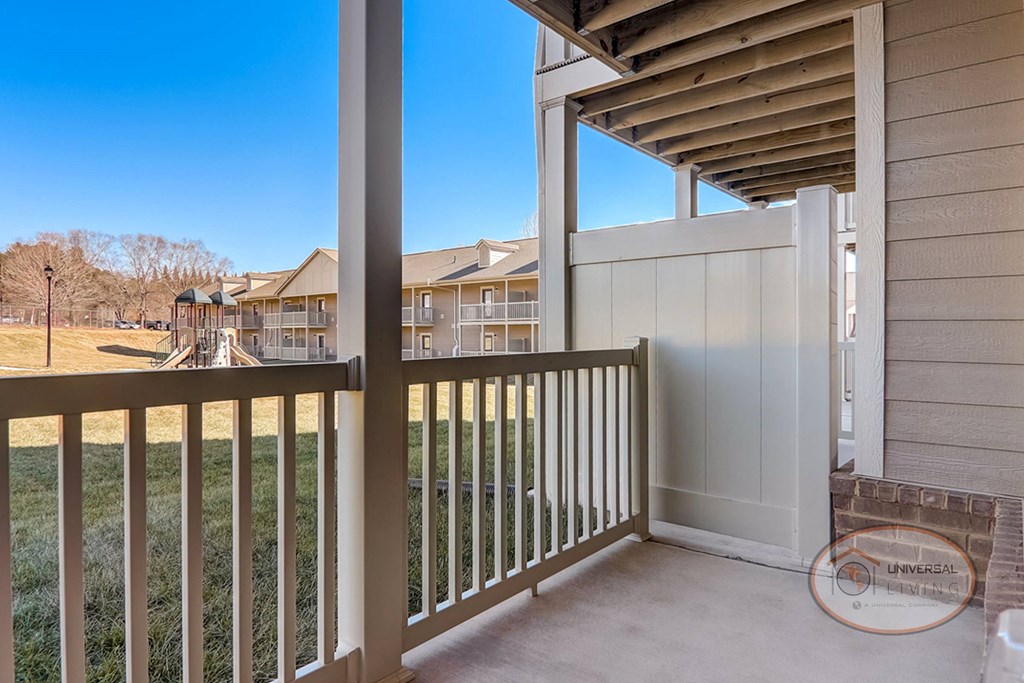 a balcony with a view of a yard and some buildings