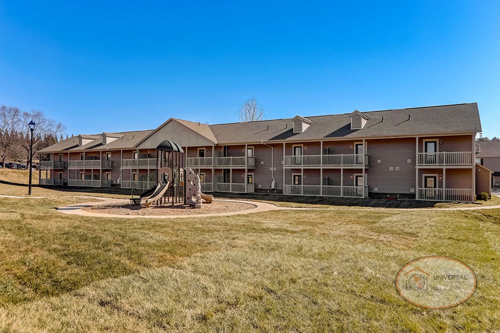 an exterior view of an apartment building with a playground
