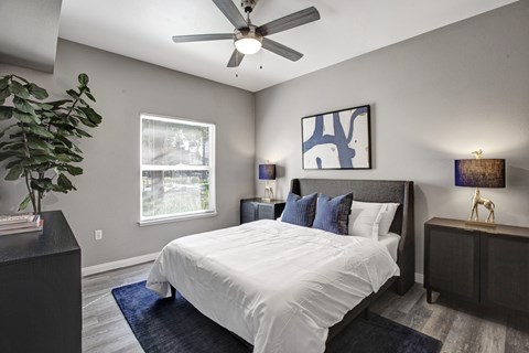 A bedroom with a large bed and a ceiling fan.