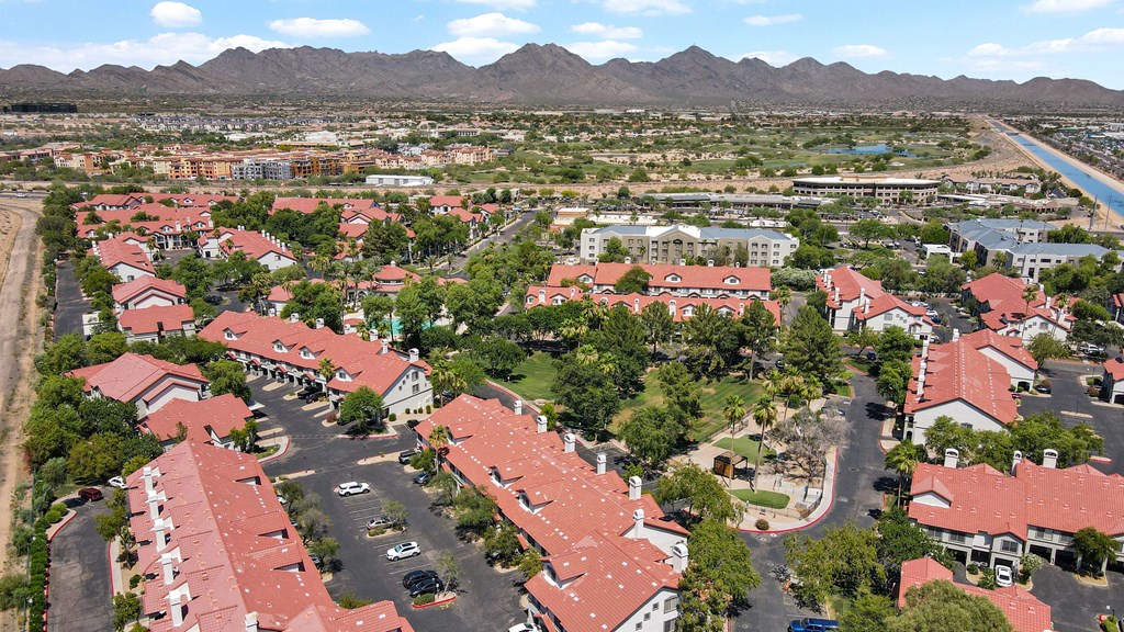A bird's eye view of a residential area with houses and a river in the background.
