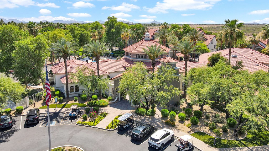 A view of a residential area with houses, trees, and parked cars.