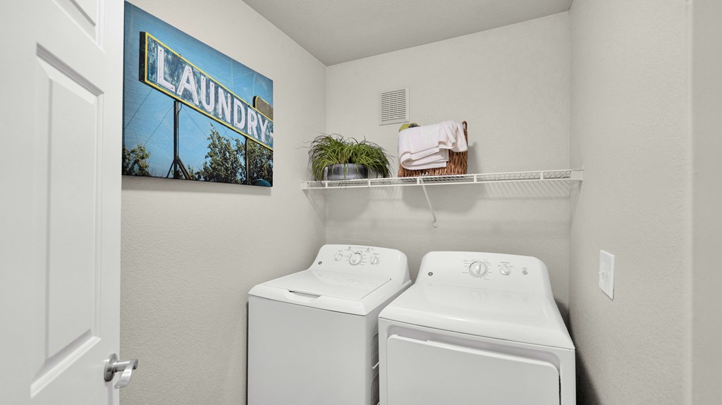 A laundry sign is on the wall above a washer and dryer.