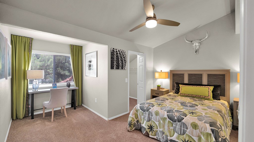 A bedroom with a bed, desk, and chair.