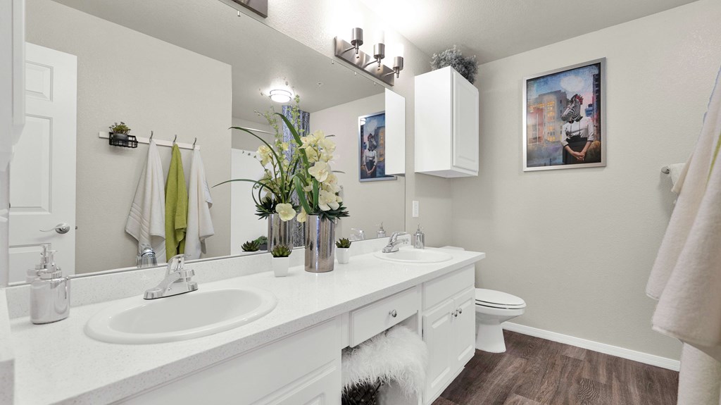 A white bathroom with a white sink and a white toilet.