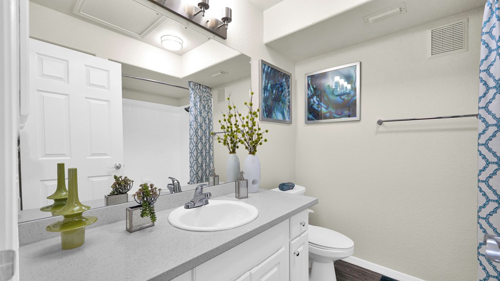 A bathroom with a white sink and a white toilet.